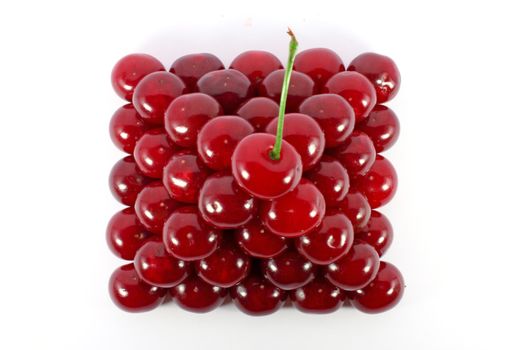 Sour cherries ordered in form of a pyramid top view isolated on white