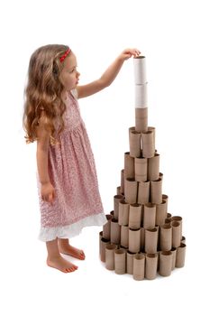 Little girl making a Christmas Tree with cardboard rolls of toilet paper