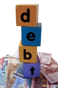 assorted childrens toy letter building blocks against a white background on money that spell debt