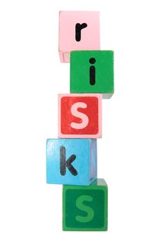 assorted childrens toy letter building blocks against a white background that spell risks