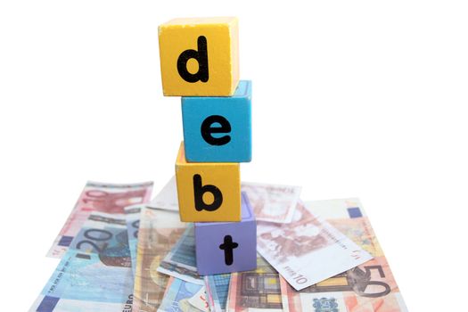 assorted childrens toy letter building blocks against a white background on money that spell debt