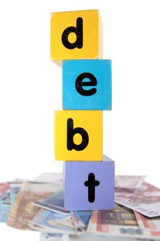 assorted childrens toy letter building blocks against a white background on money that spell debt