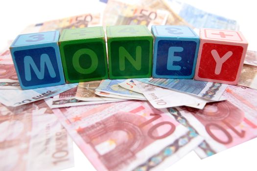 assorted childrens toy letter building blocks against a white background on money that spell money