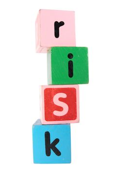 assorted childrens toy letter building blocks against a white background that spell risk