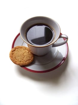 Isolated coffee cup with a biscuit on the saucer
