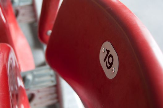 Rows of empty red seats in a football stadium