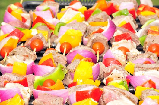 An assortment of shish kabobs grilling on an open.
