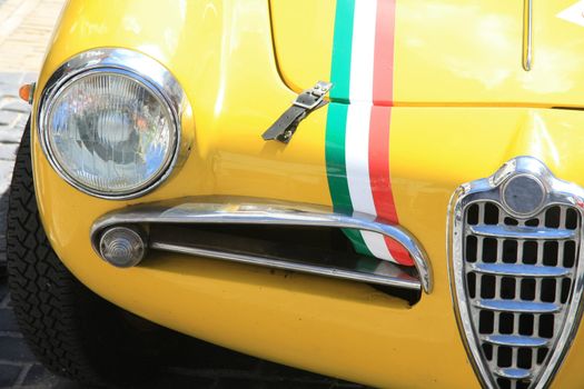 A yellow, vintage Italian sportcar in detail