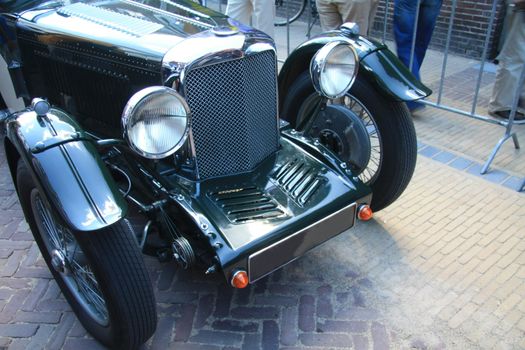 the front of a classic green car in detail