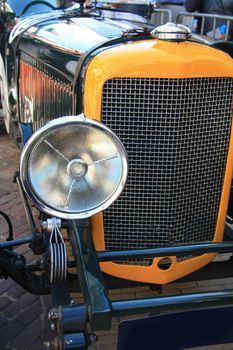 the front of a classic yellow car in detail