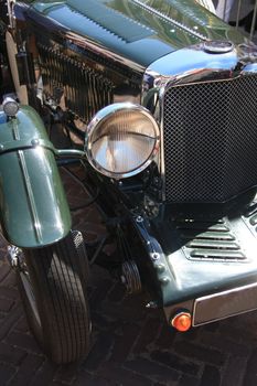 the front of a classic green car in detail