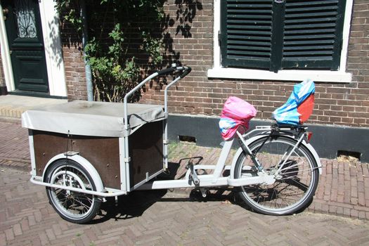 white and brown freight bicycle, tree weels and a wooden box