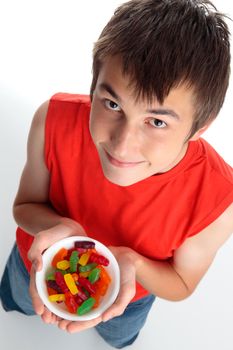 Closeup above view of a boy holding an assortment of colourful fruity flavoured lollies candy.  White background.