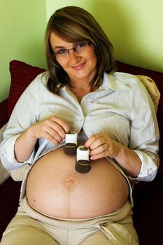 Woman in pregnancy with children's shoes