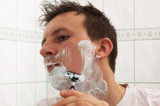 Morning routine: a man shaving before going to work
