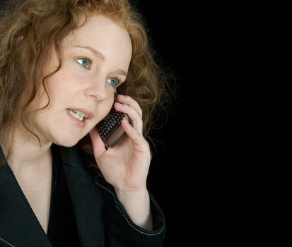 Beautiful girl speaking ion telephone, seen on black background