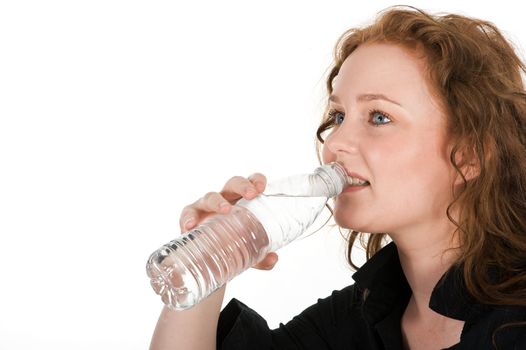 Young woman drinking mineral water directly from the bottle, isolated on white background