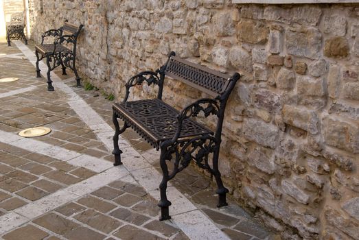 Metal  weaving benches near ancient walls in Italian town CINGOLI