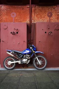 Motorcycle leaning on industrial panels in Costa Rica