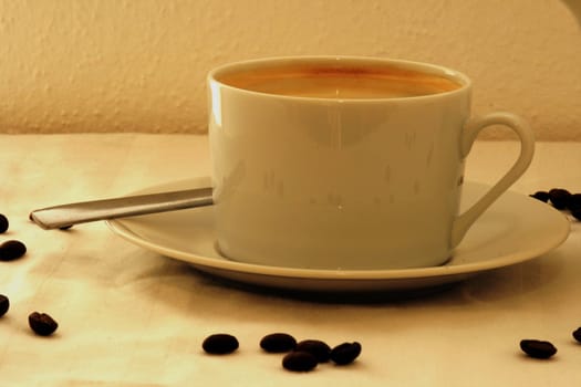 Coffee cup with coffee beans arrount it
