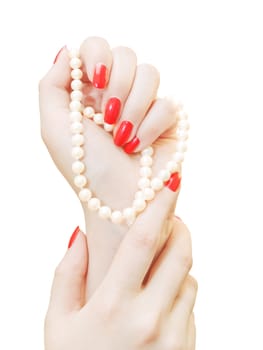 woman hands with red nails and pearls over white background