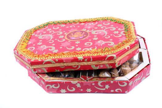 A beautiful Diwali box with traditional design containing dryfruits, isolated on white background.