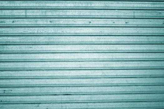 A background of a turquoise metallic shutter.