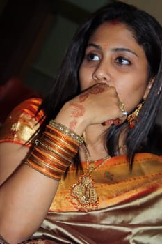 An Indian lady wearing traditional bangles in a cermony.