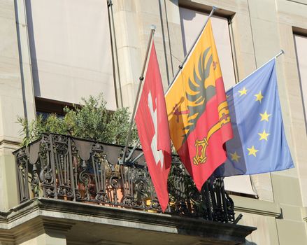 Flags of Geneva canton, Switzerland and Europe on a balcony