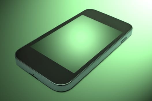 Close up and low level capturing a single unbranded smart phone arranged over a green light effect