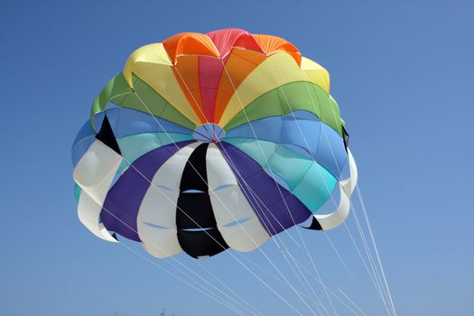 A colorful parachute on the backdrop of a blue sky.