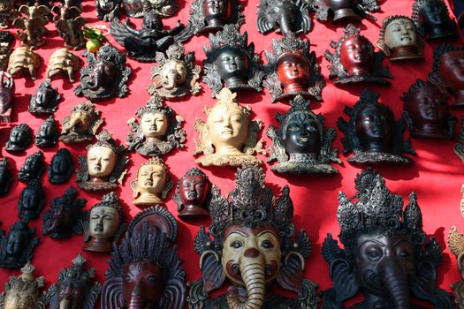 Ethnic religious masks for sale in a shop, in an Indian flea market.