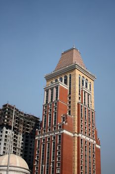 An under-construction building near a beautiful building in Mumbai, India.