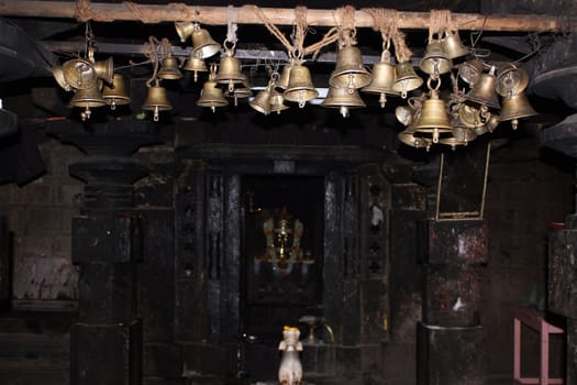 Many bells hanging in an ancient hindu temple in India.