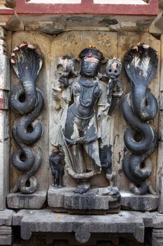 A centuries old beautifully carved idol of lord Lord Vishnu in an ancient Indian temple.