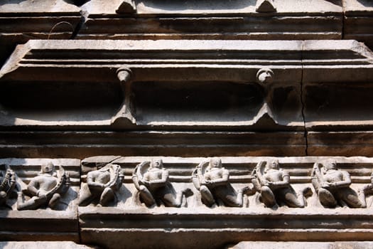 Artistic sculptures of gods on the high exteriors of a very ancient temple in India.