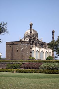 A beautiful ancient mosque in India near a garden at the Gol Gumaz in Bijapur.