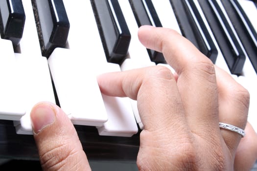 A closeup of a pianist's hand playing a chord on a piano.