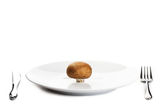 brown mushroom on a plate with knife and fork