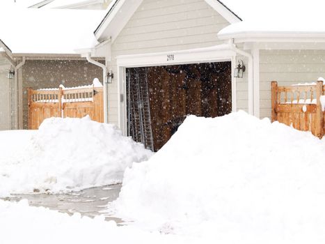 Open garage during a blizzard with piles ad piles of snow