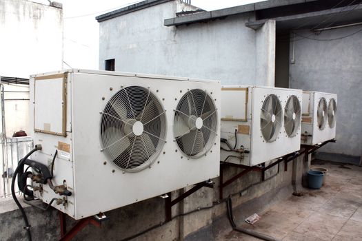 The condensor units of air conditioners installed on the top of a commercial building.