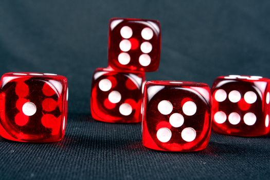 Red dices on a black fabric on a casino table.