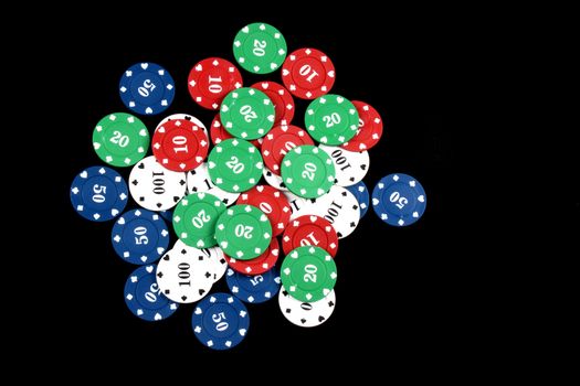 A pile of casino counters/chips, on black studio background.