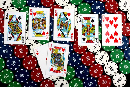 A poker hand of royal flush on the background of casino chips.