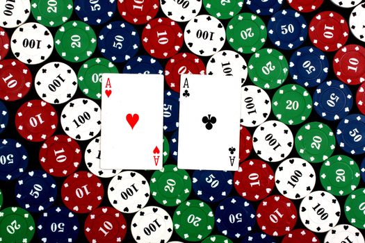 A background of poker hand of pair of aces, on colorful gambling chips.