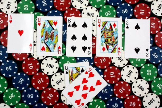 A winning poker hand showing 'Three of a Kind' combination of three queens, on gambling chips.