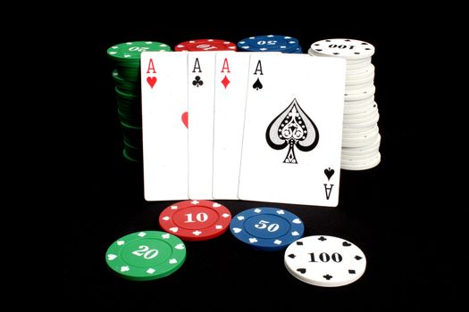 A poker hand 'Four of a Kind' kept against a stack of casino counters, isolated on black background.