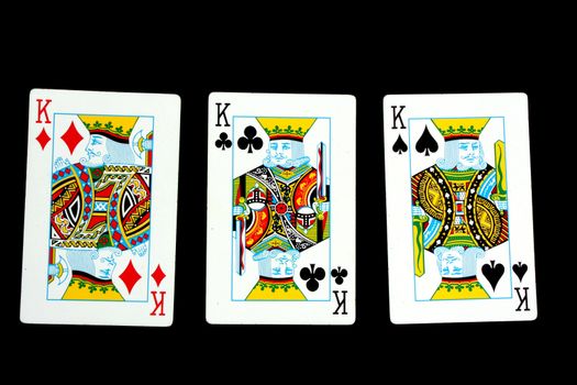 A poker hand 'three of a kind', isolated on black studio background.