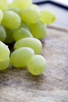 Closeup of fresh green grapes on cutting board.