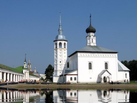 White church and building reflects in water 